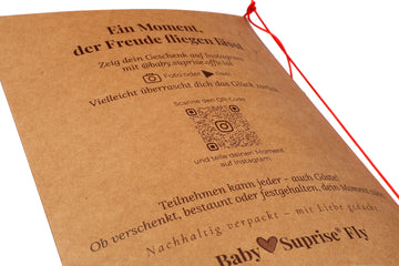 Nahaufnahme der Rückseite der Baby♡Suprise® Fly Grußkarte mit Teilnahmehinweisen